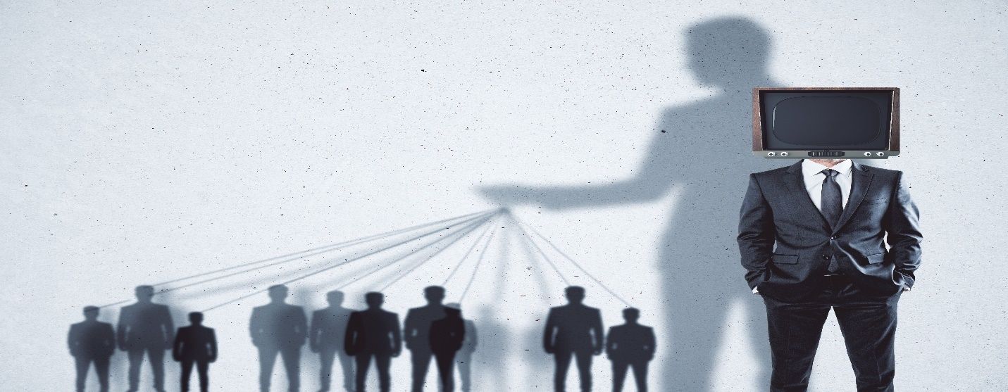 A person in a suit and tie standing in front of a crowd  Description automatically generated with low confidence